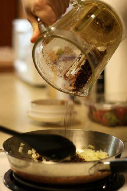 Добавляем в сковороду мелко нарезанный лук (половина луковицы) и 3-4 зубчика чеснока. Затем добавляем чили и заливаем 4 чашками воды. Подождем пока жидкость выкипит наполовину и добавим кукурузной муки для сгущения. Варим в течении пары минут. Добавляем столовую ложку томатной пасты и немного соли по вкусу.