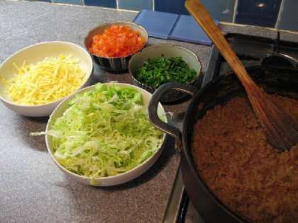 Когда мясо будет готово, нарезаем помидоры, салат и лук.