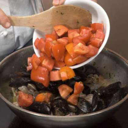 Добавьте порезанные кубиками помидоры, добавьте соль и перец чили и томите в течение 30 минут.  Обжарьте хлеб и натрите свежим чесноком.  Подавайте к столу горячим.