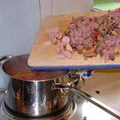 Нарезать мясо на мелкие кусочки и добавить в бульон.