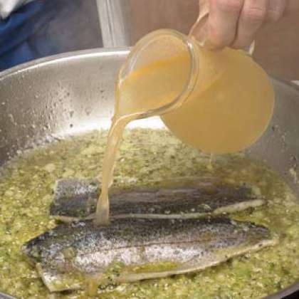 Полейте бульон на рыбу, добавьте изюм, ранее вымоченный в теплой воде в течение 15 минут. Приправить солью и готовить,до готовности рыбы.