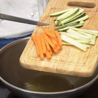 Гарнир, добавьте масло и поместите на средней огонь. Когда нагреется, добавьте цукини, морковь и сельдерей, порежьте их на полосы. Приправить с солью и перцем.