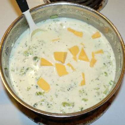 Добавить нарезанный сыр в суп и размешать. Томить на медленном огне пока сыр полностью не растворится. Подавать горячим, украсить зеленью. Приятного аппетита!