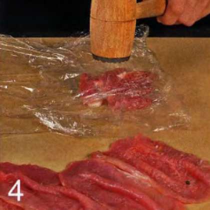 Свинину нарезать кусочками толщиной 0.5 см Аккуратно, чтобы не порвать мясо, отбить каждый кусочек между двумя слоями пищевой пленки  в тонкий пласт. Выложить куски свинины  на поднос.