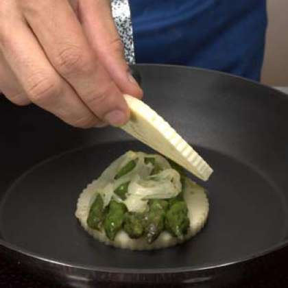 Порежьте Montasio на круглые ломтики. Поместите первый диск сыра в центре сковороды. Добавьте овощи и затем накройте их вторым ломтиком сыра.