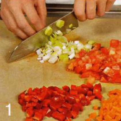 Лук порей, помидор и сладкий перец вымыть, из перца вырезать сердцевину. Порезать все овощи небольшими кубикам, затем растопить в сковороде половину сливочного масла. Нарезанные овощи обжарить в течении 5 мин.