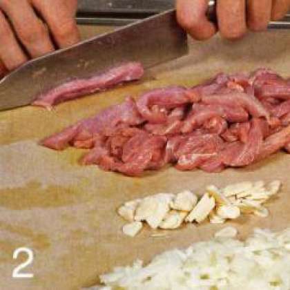 Мясо нарезать небольшими кусочками.  Лук и оставшийся чеснок очистить  и тонко нарезать.