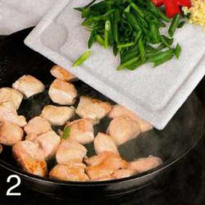 Оставшееся куриное мясо нарезать  маленькими кусочками и обжарить  в разогретом масле, 7 мин., постоянно  помешивая. Добавить зеленый лук, перец  и чеснок, обжаривать еще 2-3 мин.