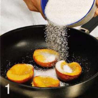 Персики вымыть, разрезать пополам,  удалить косточки. Выложить половинки  персиков на сковороду срезом вверх,  посыпать сахаром. Влить в сковороду  0,25 стакана воды, накрыть крышкой.  Готовить 35-40 мин. на медленном огне.