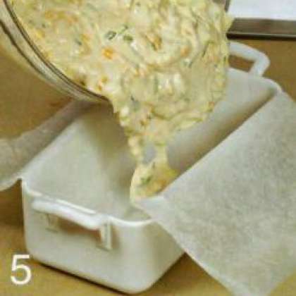 Прогреть духовку до 200 °С. Смазать форму для запекания растительным маслом и застелить  пергаментом Уложить луковое тесто  в форму.