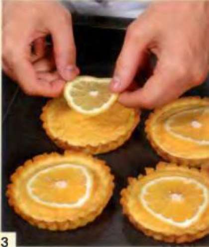 Оставшуюся половину лимона порезать тонкими кружками, по одному кружку положить на каждую тарталетку.