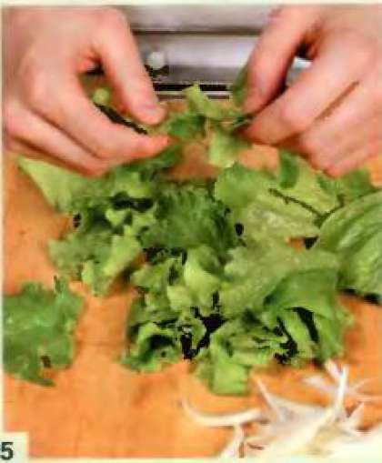 Салат разобрать на листья, помыть и обсушить бумажными салфетками. Крупно нарвать и положить в салатницу. Лук почистить, порезать тонкими полукольцами. Добавить лук и вермишель в салат.