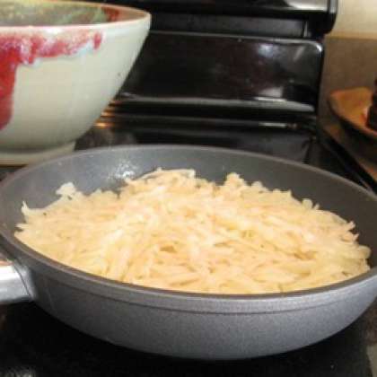 Растопить 2-4 столовые ложки сливочного масла в сковороде. Добавить тертый картофель и соль. Готовить на среднем огне несколько минут, помешивая два или три раза, чтобы картофель смешался со сливочным маслом. Примять картофель лопаткой и жарить еще 10 минут. Накрыть крышкой и готовить еще 5 минут.