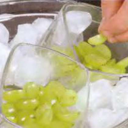 Засыпать ягоды в бокалы, наполовину. Большую миску  заполнить кубиками льда. Поместить  в нее бокалы под наклоном приблизительно  45° градусов.  Зафиксировать бокалы под углом можно и с помощью сухой фасоли. Но лед способствует более быстрому застыванию желе.