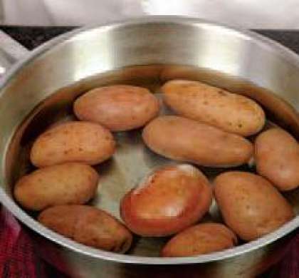 Картофель хорошенько помыть щеткой.  В кастрюле закипятить воду, посолить. всыпать картофель и варить до  готовности. Дать картофелю остыть.