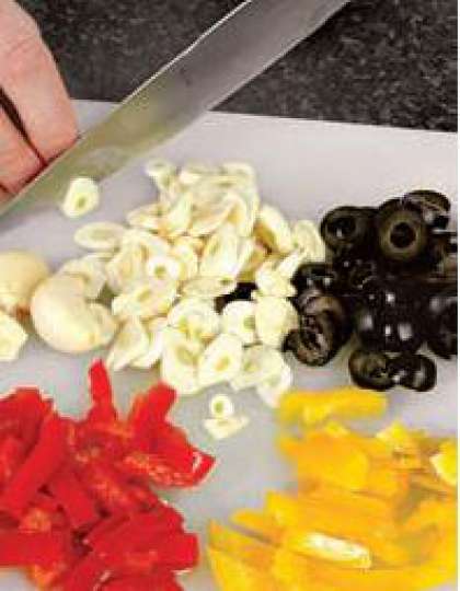 Сладкий перец вымыть, порезать на две половины, извлечь семена и плодоножку,  нарезать кубиками. Чеснок очистить  и нарезать кружочками. Маслины нарезать колечками.