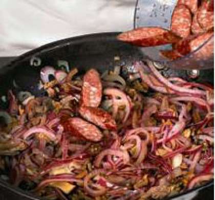 В сковороду где жарится  сало вкинуть колбаски, красный лук и белые грибы, посолить, поперчить по вкусу. Жарить до готовности,  7–8 минут.