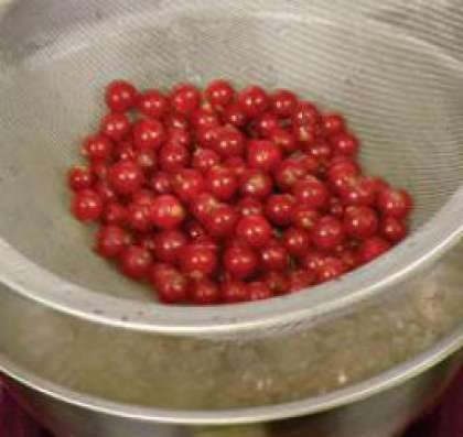 Снять с веточек ягоды смородины,  тщательно перебрать, промыть и дать высохнуть.  Довести воду до кипения в широкой кастрюле.  Смородину поместить в дуршлаг и опустить в кастрюлю таким образом, чтобы  ягоды покрылись водой. Прогреть ягоды в течение 2 минут.