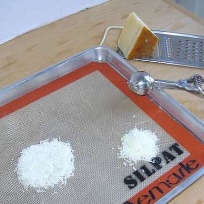 Разогрейте духовку до 375 F. Уложите специальный силиконовый лист для выпечки на противень. Измельчаем сыр с помощью мелкой терки. Распределяем сыр по листу небольшими кружками на расстоянии друг от друга. Посыпать перцем и паприкой. Выпекать 5-7 минут.