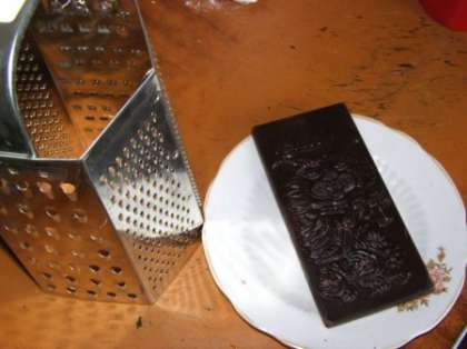 Трем черный шоколад с помощью терки.