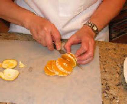 Очистите и порежте апельсин на кружки. Выложите в тарелку.