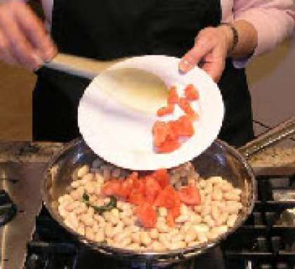 Добавить помидоры и готовить в течении 20 минут пока бобы не станут мягкими.