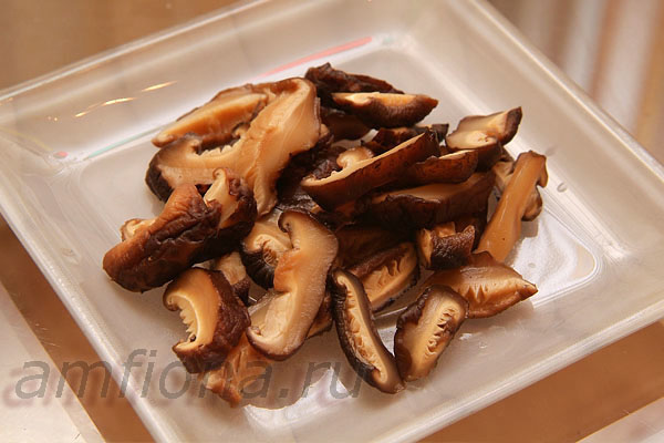 Несколько сухих грибов шиитаке предварительно замочите, промойте и сварите, а затем нарежьте пластинками, удалив жёсткие ножки. При варке грибов можно добавить в воду соевый соус и сахар или мирин (это помогает вкусу грибов раскрыться).