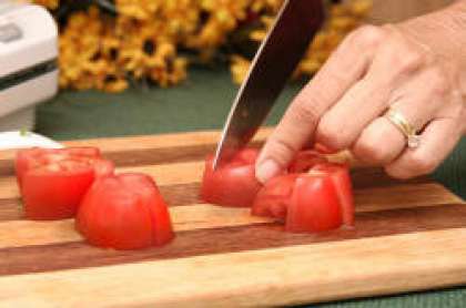 Помойте помидоры и разрежьте их на 8 частей.