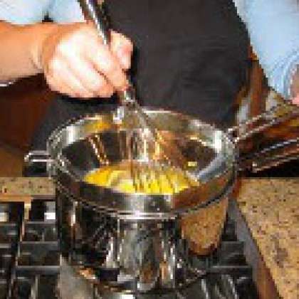 В миску добавьте желтки и готовьте помешивая на пару, пока они не станут "пушистыми"
