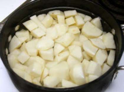 Для начала помойте и почистите картошку. Затем нарежьте кубиками и переложите в кастрюлю, залейте водой так, чтобы покрыло слой картофеля.