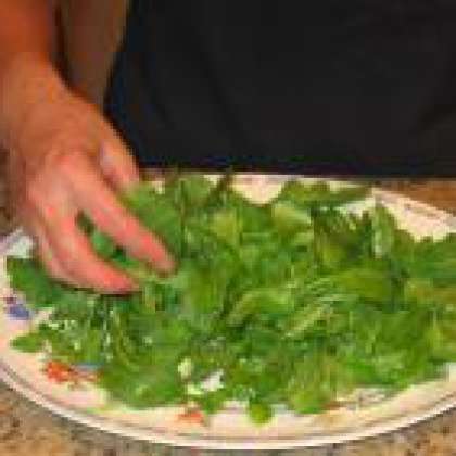 На тарелке разложите в изобилии салат рукколы.