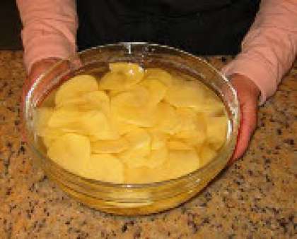 Грибы замочите в тёплой воде на 30 минут, слейте воду и грубо порубите.  Нарежте очень тонко картофель, положите в миску и заполните водой, что бы она лишь покрывала весь картофель