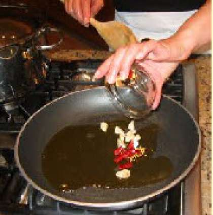 В сковороде разогрейте масло, добавьте чеснок и  красный перчик. Обжарьте несколько секунд помешивая.
