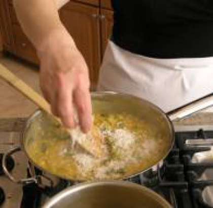 Примерно через 18 минут добавьте сливочное масло, сыр и перемешайте. Добавьте бульон. Доведите рис до готовности. И можно подавать к столу.