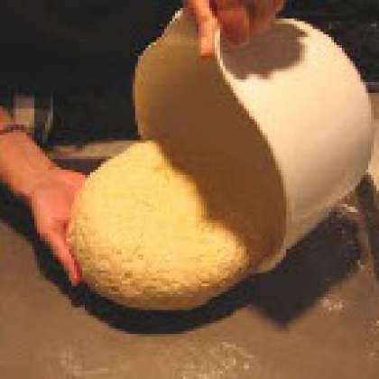 Смажьте оливковым маслом форму для выпечки (30 х 40 см). Аккуратно выложите тесто в форму.