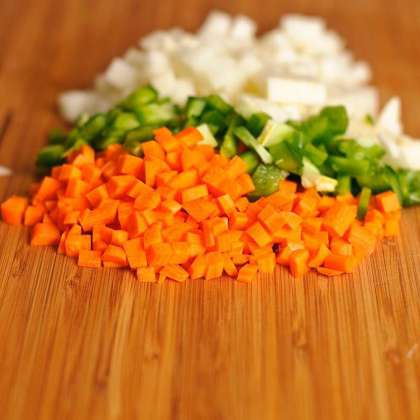 Промыть, почистить овощи  (морковь, перец, картофель, помидор и чеснок). Затем, нарезать небольшими кубиками. Отложить в сторону.