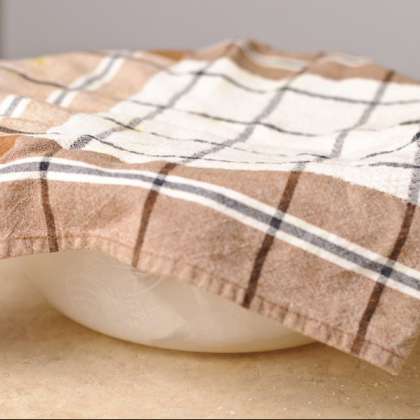 Смажьте тесто небольшим количеством масла, положите во влажную ткань и накройте другим полотенцем. Пусть тесто постоит в течении 30 минут.