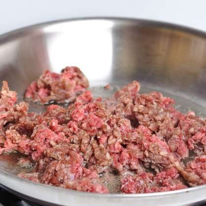 Нагрейте сковороду до средне-высокой температуры, налейте масло и положите мясной фарш.