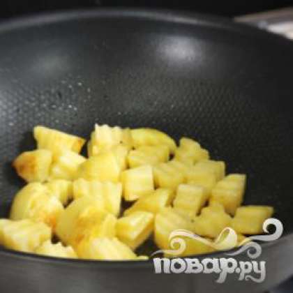 Разогреть масло в сковороде. Нарезать картофель кубиками и обжаривать до золотистого цвета.