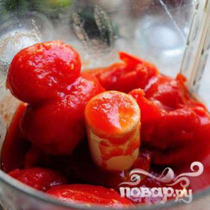 Поместите консервированные томаты в кухонный комбайн.