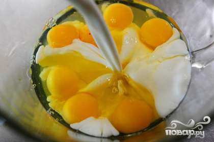 В миску разбейте яйца и залейте половину молока.