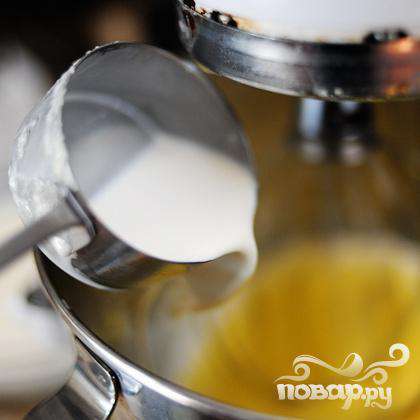 Медленно заливаем ванильный крем в яичные желтки, продолжая взбивать.