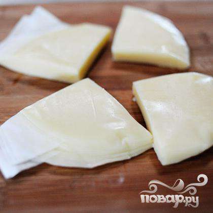 Разрезаем сыр на равные кусочки.