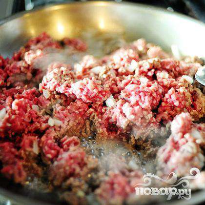 Обжариваем говяжий фарш вместе с мелко нарезанным лучком. Добавьте чеснок, тмин, молотый красный перец, майоран и соль.