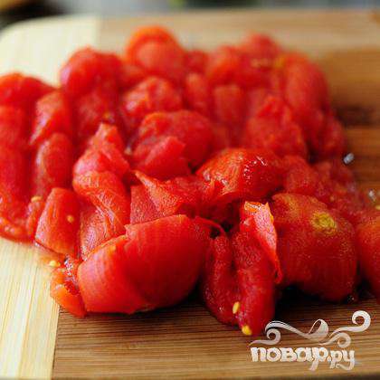 Слейте жидкость и нарежьте консервированные помидоры.
