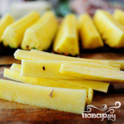 Нарежьте ананас на длинные ломтики.