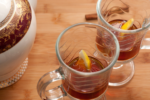 В стаканы налейте ром, положите по кусочку лимона и налейте процеженный чай.