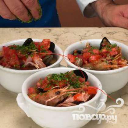 Обложить горшочки с морепродуктами нарезанными помидорами и оливками (без косточек), посыпать петрушкой. Залить бульоном. Выпекать в духовке при температуре 180 ° С в течение 5 минут. Подавать с кусочками хлеба.