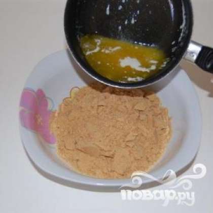 Развести желатин в холодной воде на 15 минут. Растопить сливочное масло в кастрюле и перемешать с дробленым печеньем.