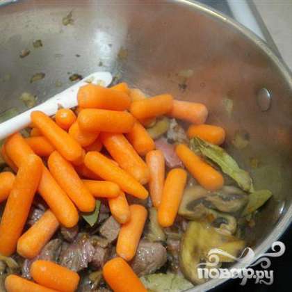 Грибы обжарить на малом огне в течении 3 минут, затем добавить морковь и жарить на малом огне еще 2 минуты. Бросить в сковороду кусочки мяса, готовить еще примерно 3 минуты. Добавить 1 столовую ложку красного перца и 1 чайную ложку майорана.